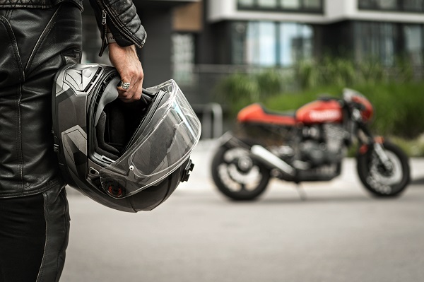 Biker walks to motorcycle holding helmet in hand