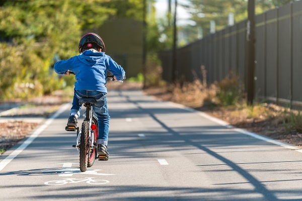 Boy riding his bicycle in a protected bike lane.