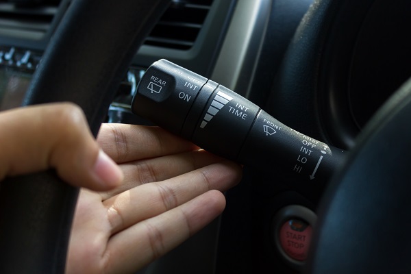 closeup of a driver using the turn signal of a vehicle.