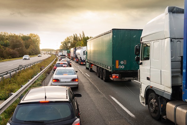 a traffic jam on a highway featuring cars, semis, and 18-wheelers