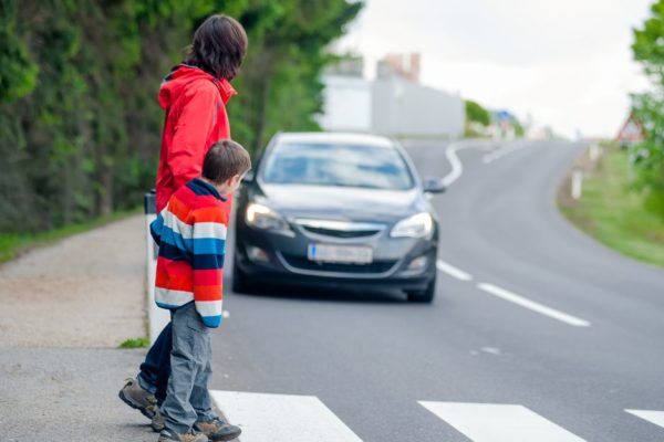 Adult and child in a crosswalk as car approaches