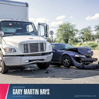 Scene of a truck and a heavily damaged car after a collision on the road, illustrating a serious truck accident.