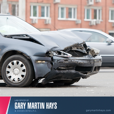 Close up of a car with a crushed front end after a collision, representing a serious car accident.