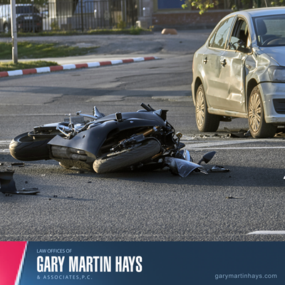 Motorcycle lying on its side and damaged after a crash with a car, depicting a motorcycle accident scene.