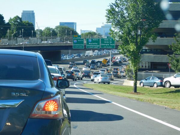 Bumper-to-bumper Atlanta traffic congestion and highway crash risks on Interstate 75 North and Interstate 85 North, showing vehicles backed up near exits for 10th St, 14th St, and Georgia Tech.