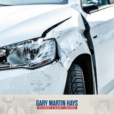 A white car with a smashed front bumper after an Atlanta car accident caused by recklessness
