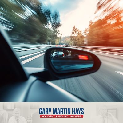 A car speeds down the Atlanta highway with another car in the rear-view